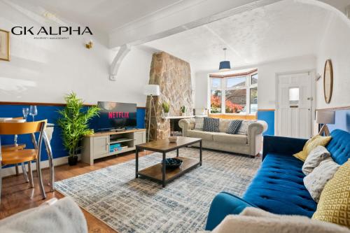 a living room with a blue couch and a table at Heartwarming Windsor Cottage with Free Parking - Perfect for Contractors, Relocators and Long Term Stays! Weekly And Monthly Stay Deals in Windsor