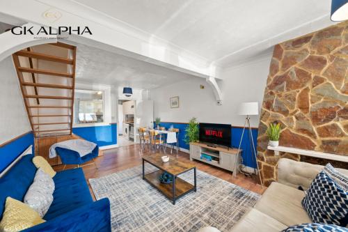 a living room with a blue couch and a fireplace at Heartwarming Windsor Cottage with Free Parking - Perfect for Contractors, Relocators and Long Term Stays! Weekly And Monthly Stay Deals in Windsor