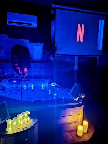 a dark room with a tub with a sign and candles at Les Spas de la mer, Appart&Spa Canopée, 100m de la plage, Love Room in Le Grau-du-Roi