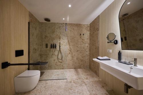 a bathroom with a shower and a toilet and a sink at Cala Ponte, a Tribute Portfolio Hotel in Polignano a Mare
