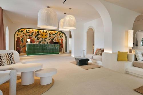 a living room with white furniture and a colorful wall at Cala Ponte, a Tribute Portfolio Hotel in Polignano a Mare