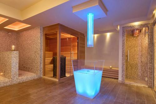 a bathroom with a blue trash can in a room at Cala Ponte, a Tribute Portfolio Hotel in Polignano a Mare