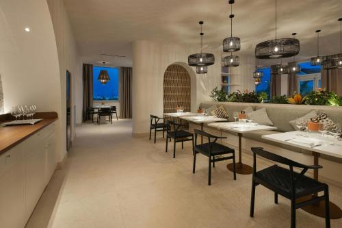 a dining room with a long table and chairs at Cala Ponte, a Tribute Portfolio Hotel in Polignano a Mare