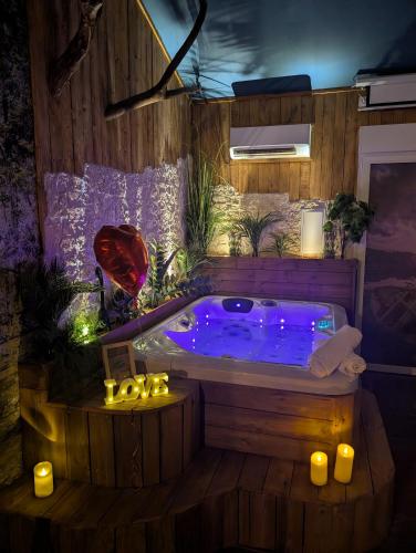 a jacuzzi tub in a room with candles at Les Spas de la mer, Appart&Spa Canopée, 100m de la plage, Love Room in Le Grau-du-Roi