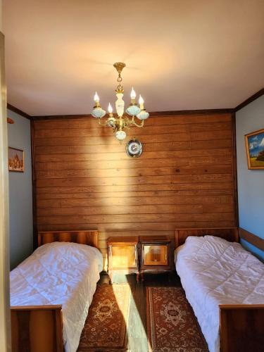 a bedroom with two beds and a chandelier at Sagamo in Sagamo