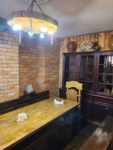 a room with a wooden table and a brick wall at Sagamo in Sagamo