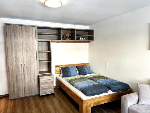 a bedroom with a bed with blue pillows at Kitz-Studio in Größing