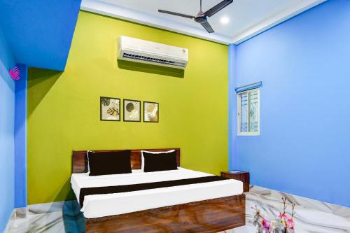 a bedroom with a bed with a green wall at Hotel O Elegant Stay CDA in Cuttack