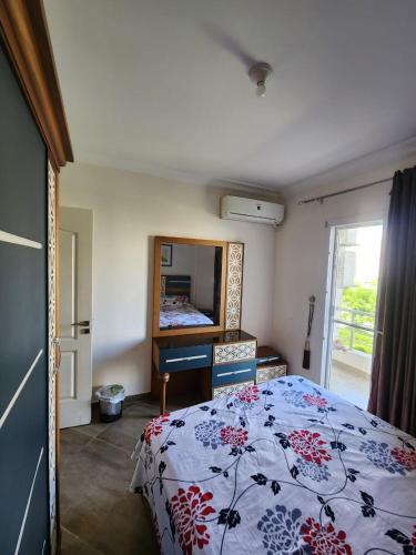 a bedroom with a bed and a mirror in it at العالمين in El Alamein