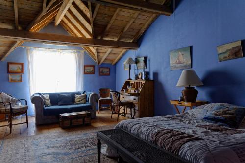 a bedroom with blue walls and a bed and a couch at Le Domaine de Saint Veran in Orgon