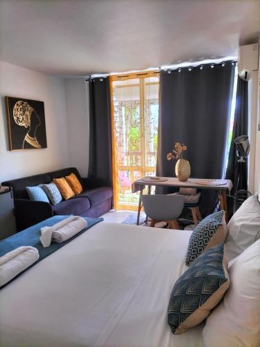 a bedroom with a large bed and a living room at Bonheur à la résidence Savane in Le Gosier