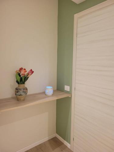 a vase of flowers sitting on a shelf next to a door at Pixel Sea Home a Misano Brasile 300 m dal mare e free parking, Misano World Circuit a 7 minuti di macchina in Misano Adriatico