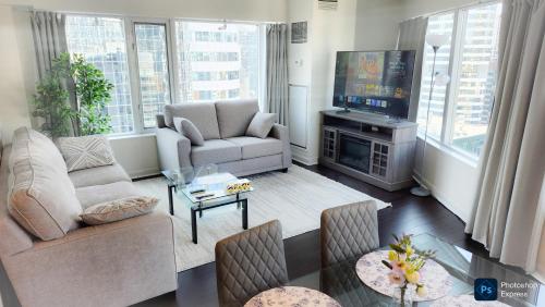 a living room with a couch and a tv at Pantages Skyline Suite in Toronto Centre - Free Parking in Toronto