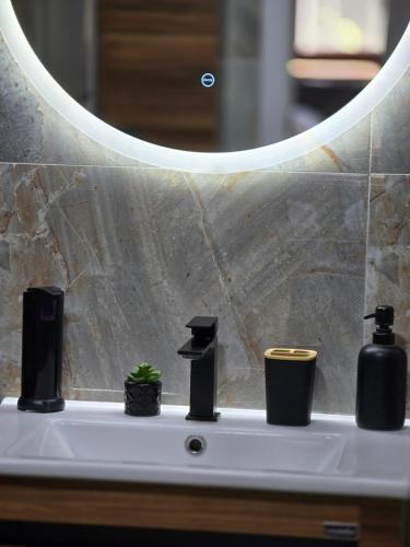 a bathroom sink with two soap dispensers and a mirror at Vikendica Fruškogorski kutak - Fruška Gora in Čerević