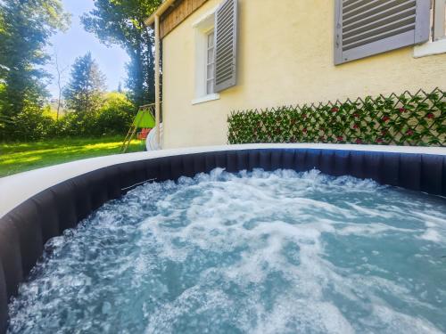 a hot tub with water in it next to a house at Maison Nature, Jacuzzi, 10 min de Disneyland Paris in Montry