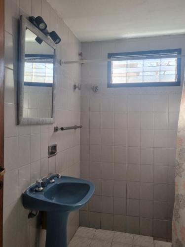 a bathroom with a blue sink and a mirror at Las Camelias - chalet zona centro, aerosillas in Villa Carlos Paz