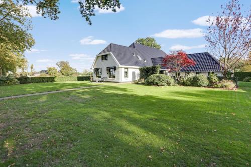 a white house with a large grass yard at Dalerheugte Wellness B&B in Dalerveen