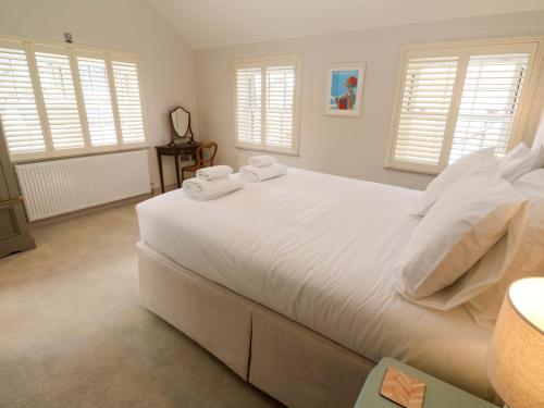 een slaapkamer met een groot wit bed met handdoeken erop bij 21 Alverton Street in Penzance