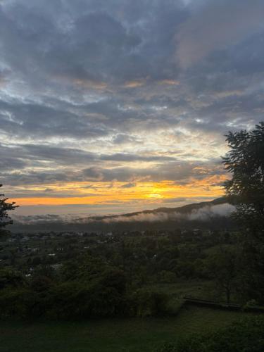 a sunset over a city with clouds in the sky at Squirrel snuggle2 in Kota Bāgh
