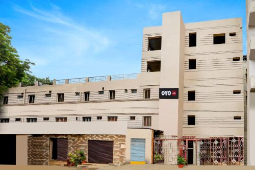 a white building with a sign on it at Hotel O Woodlands in Kurnool