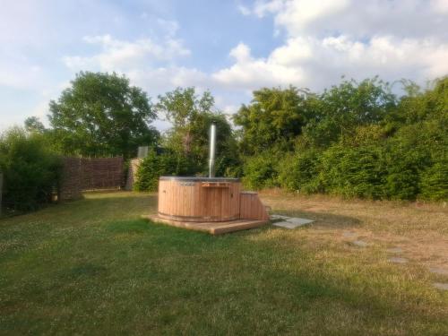 a hot tub in the middle of a yard at Hill Top Hideaway Shepherds Hut with Hot Tub in Woodham Mortimer