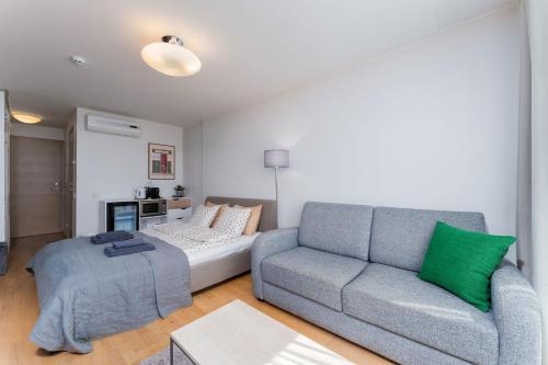 a living room with a gray couch and a green pillow at Lovely Aisa Studio | Balcony in Pärnu
