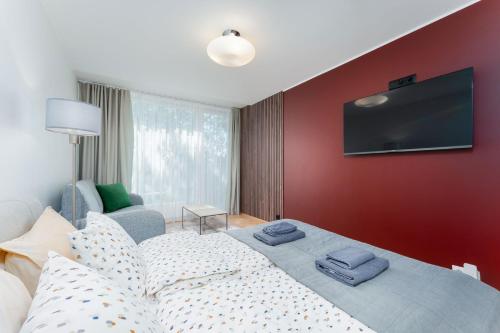 a bedroom with a bed with a tv on the wall at Lovely Aisa Studio | Balcony in Pärnu