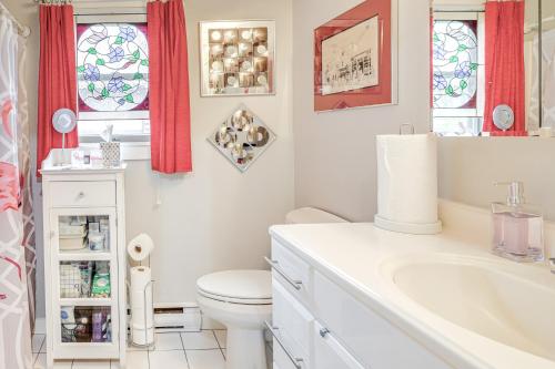 a white bathroom with a toilet and a sink at Cape Cod Condo on the National Seashore Bike Path! in Provincetown