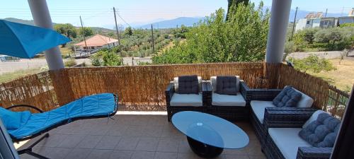 a patio with couches and chairs and an umbrella at Guest House Kastraki in Nafpaktos
