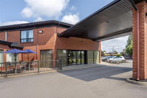 a brick building with a black awning in a parking lot at Best Western Hotel Brossard in Brossard