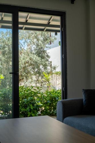 an open glass door with a couch and a table at Güneş Boutique Hotel - Oludeniz in Oludeniz