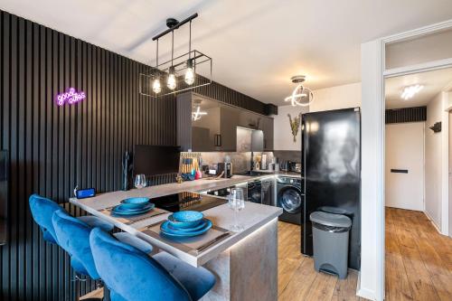 a kitchen with a table and blue chairs in a room at Stylish Brayford Pool 2-Bed City Retreat in Lincoln