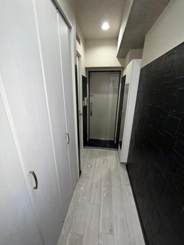 a hallway with a door and a tile floor at メルシアターリゾート1001 in Wada