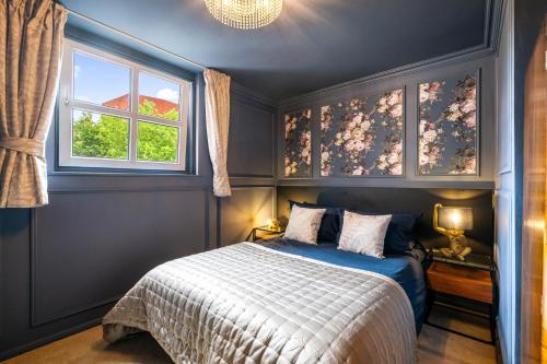 a bedroom with a bed with blue walls and a window at Stylish Brayford Pool 2-Bed City Retreat in Lincoln