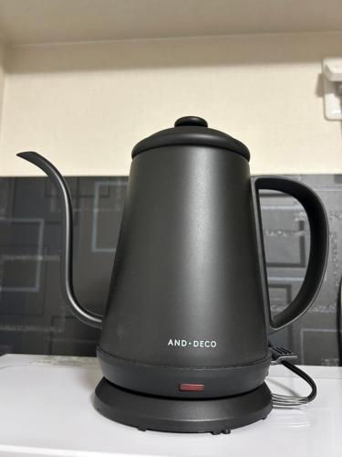 a black tea kettle sitting on top of a counter at メルシアターリゾート1001 in Wada