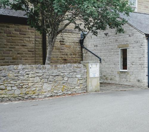 a brick wall next to a building with a tree at No 1 - Bakewell in Bakewell