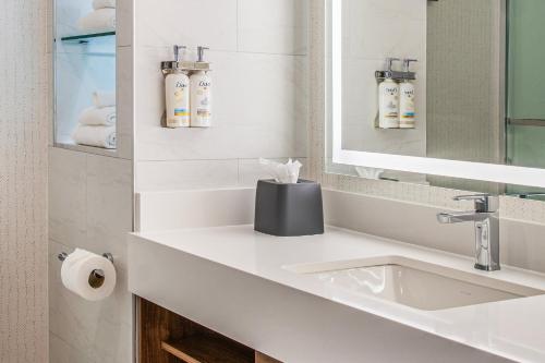 a white bathroom with a sink and a mirror at Holiday Inn Los Angeles Gateway-Torrance by IHG in Torrance