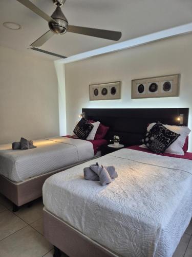 a bedroom with two beds and a ceiling fan at Suite Luxury en Puerto Santana in Guayaquil