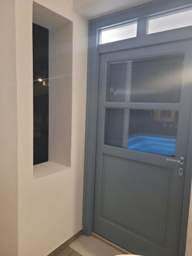 a gray door in a room with a mirror at Located by the sea one beachfront Private Captain Lazaros Pool Villa with loft in 750sqm spacious private plot-Jacuzzi-sunrelax-furnished terace-gazebo-private parking,sleep 3 adults and 2 children, just steps from the Black Beach-Seaview in Perissa
