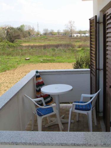a table and chairs on a balcony with a table at Apartments in Lopar - Insel Rab 17729 in Lopar