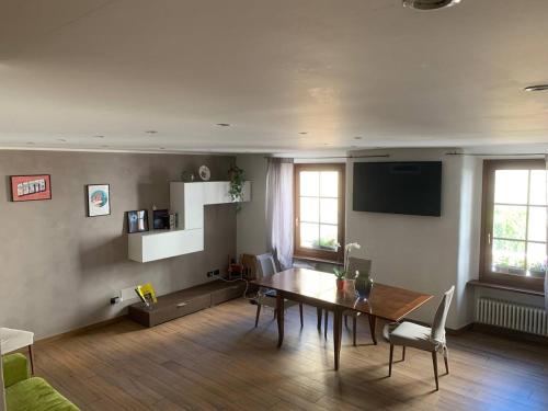 a living room with a dining table and a television at Aosta Center large Apartment with large shower in Aosta