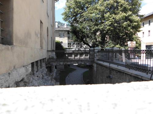 a bridge over a small canal in a city at Aosta Center large Apartment with large shower in Aosta
