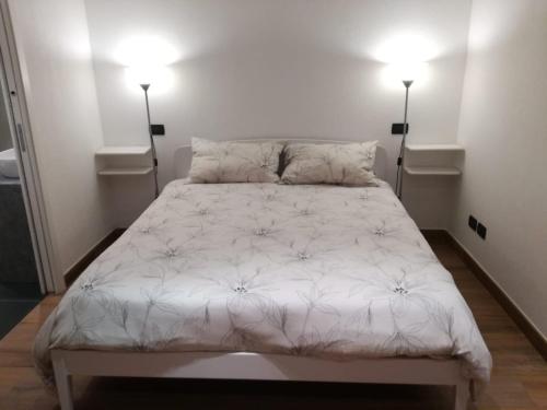 a bed in a room with two lights on at Aosta Center large Apartment with large shower in Aosta