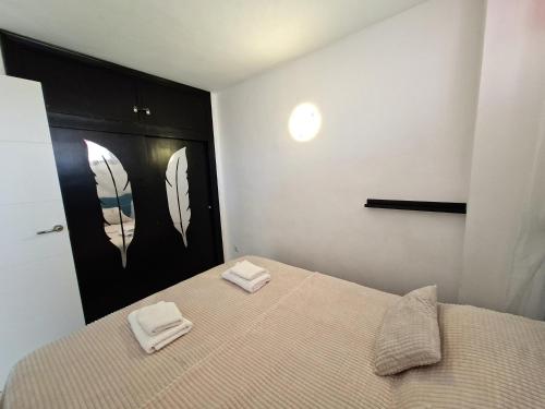 Un dormitorio con una cama con dos toallas encima. en Apartment Sea View in Rincon de Loix- free parking, pool, Wi-Fi, new air conditioning, en Benidorm