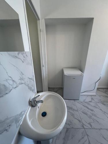 Un baño blanco con un lavabo y un cubo de basura. en Casa Bianca, en Marsella