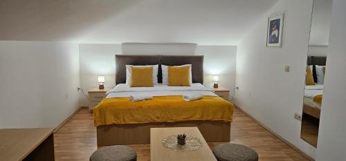 a bedroom with a large bed with yellow sheets and two lamps at Central Suites in the heart of Ohrid in Ohrid