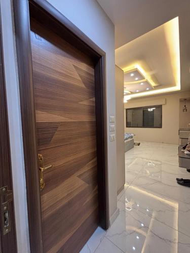a wooden door in a room with a lobby at شقة واسعة مع ترس كبير in Amman