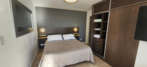 a small bedroom with a bed and a closet at La Perla I in Mar del Plata