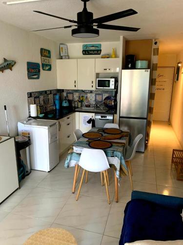 une cuisine avec une table et un réfrigérateur dans l'établissement Cap d'Agde méditerranée studio 4 pers piscine rdc parking gratuit, au Cap d'Agde