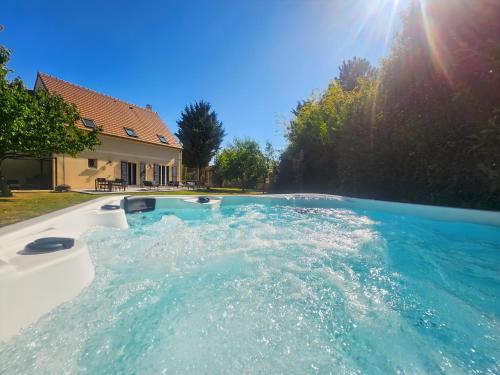 une grande piscine d'eau dans une cour dans l'établissement Maison Cosy Campagne, Terrasse & Spa, à Le Plessis-Feu-Aussoux
